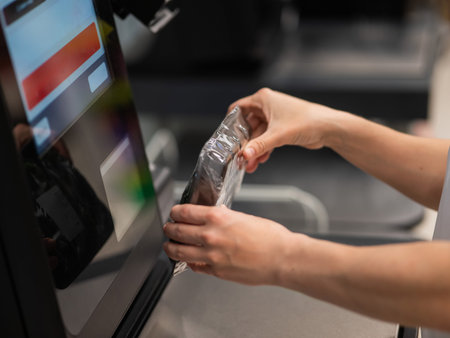 Woman scanning a package of cucumbers at a self-service checkout