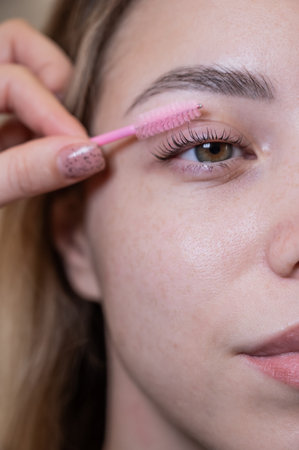 Caucasian woman brushing her eyelashes after laminationの写真素材