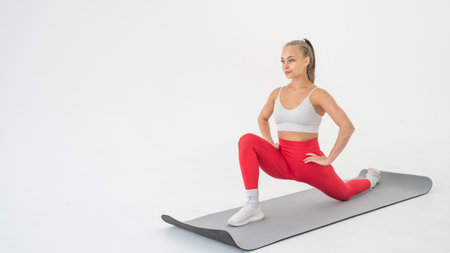 Young woman doing splits exercises on white background