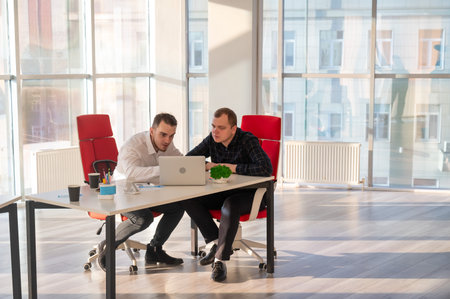 Two Caucasian men chatting in an office