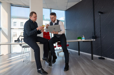 Two men discussing work in an office.