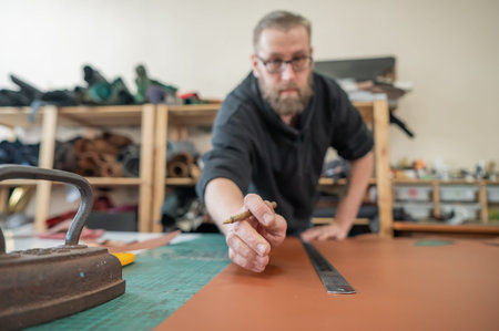 Caucasian bearded man working as a tanner in a workshop