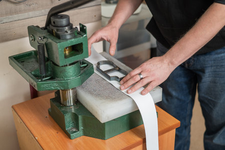 A tanner works with a press in his workshop