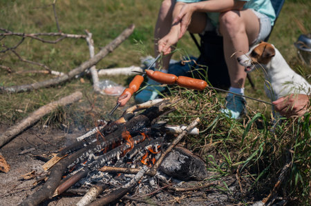 Caucasian couple roasting sausages over a fireの写真素材