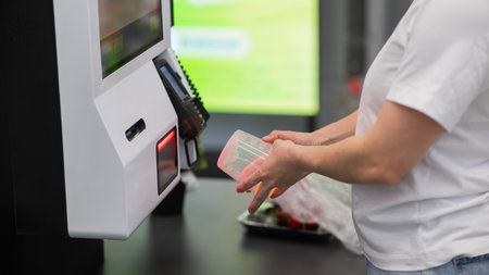 A woman scans items at a self-checkoutの写真素材