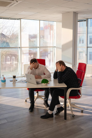 Two Caucasian men solve problems at workの写真素材