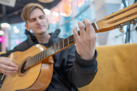 Caucasian man sitting in cafe and playing guitar