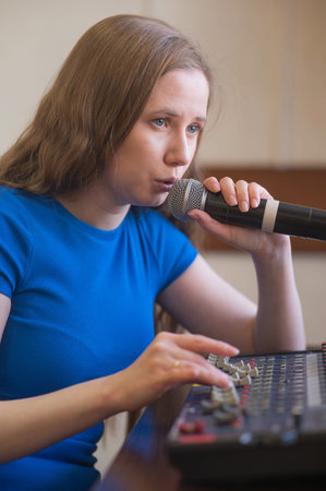 Young woman mixing live sound. Girl recording a song in the studio