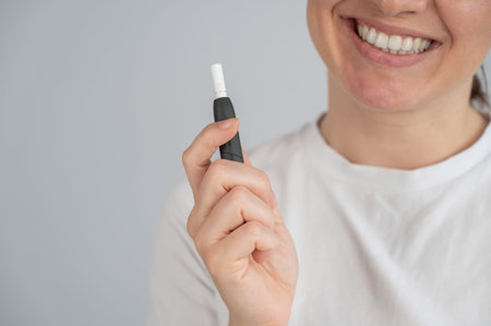 Woman holding tobacco heating system. Electronic cigarette