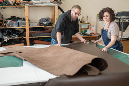 A man and a woman work as tanners in a workshop