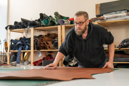 Caucasian bearded man working as a tanner in a workshop