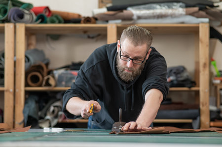 Caucasian bearded man working as a tanner in a workshopの写真素材