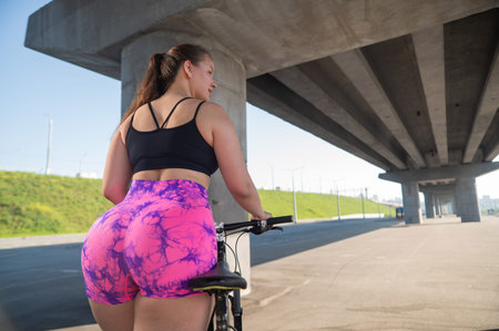 Caucasian woman in short shorts riding a bicycle