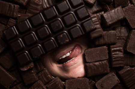 The face of a woman surrounded by chocolates.の写真素材