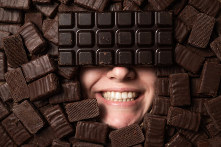The face of a caucasian woman surrounded by sweets. Girl under a bunch of chocolates