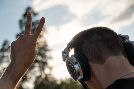 Man putting on headphones outdoorsの写真素材