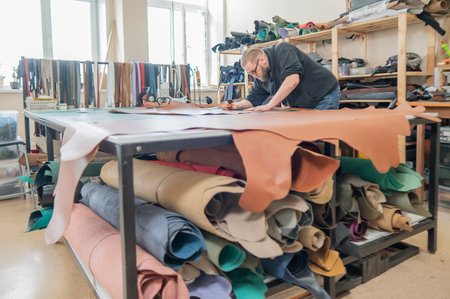 Caucasian bearded man working as a tanner in a workshop