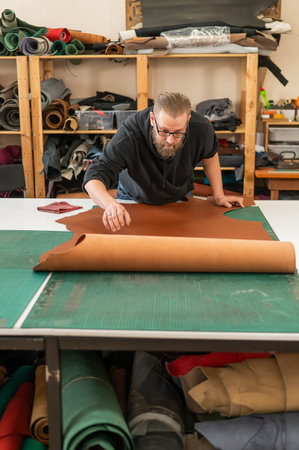 Caucasian bearded man working as a tanner in a workshop