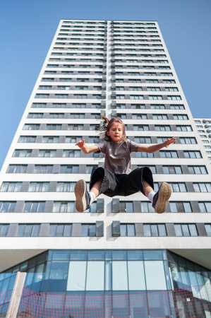 A girl jumps on an outdoor trampolineの写真素材