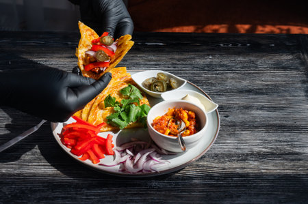 A chef wearing black gloves prepares fajitasの写真素材