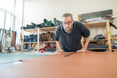 Caucasian bearded man working as a tanner in a workshop