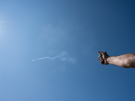 A man fires a flare gun with emergency fire. Close-up of a mans handの写真素材