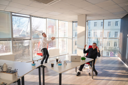 Two Caucasian men celebrate success at work