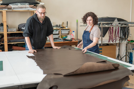 A man and a woman work as tanners in a workshop