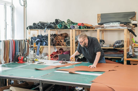 Caucasian bearded man working as a tanner in a workshop
