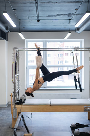 Caucasian woman doing pilates on reformer