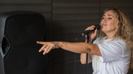 Caucasian woman singing into microphone in music studio