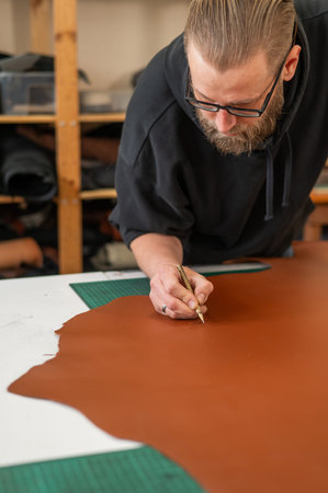 Caucasian bearded man working as a tanner in a workshop
