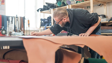 Caucasian bearded man working as a tanner in a workshop