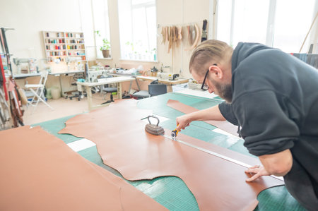 Caucasian bearded man working as a tanner in a workshop