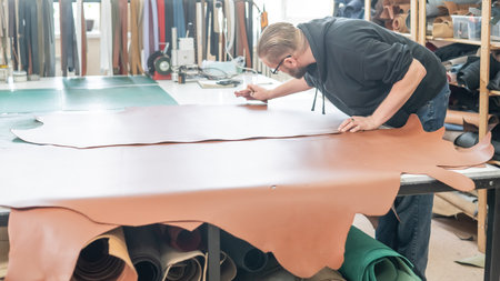 Caucasian bearded man working as a tanner in a workshop
