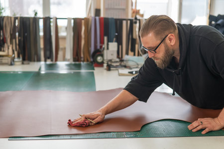 Caucasian bearded man working as a tanner in a workshopの写真素材