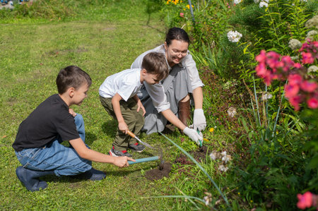Caucasian woman tending her garden with her sons