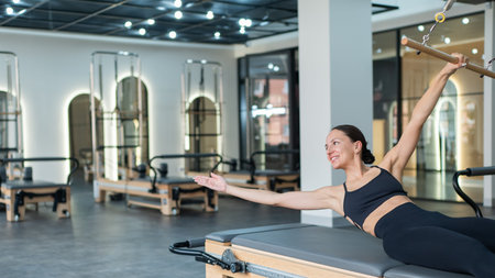 Caucasian woman doing exercises on reformer machine