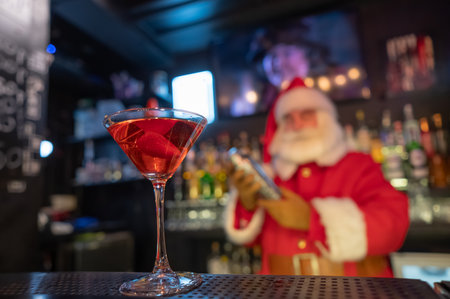 Santa Claus works at the bar making cocktails in a shakerの写真素材