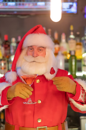 Bartender dressed as Santa Claus makes strawberry cocktail in pubの写真素材