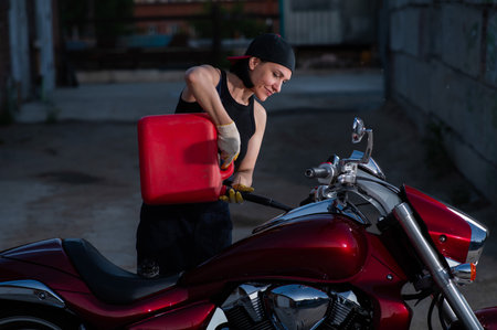 woman refueling motorcycle from canisterの写真素材
