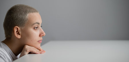 A woman with short hair peeks out from under a tableの写真素材