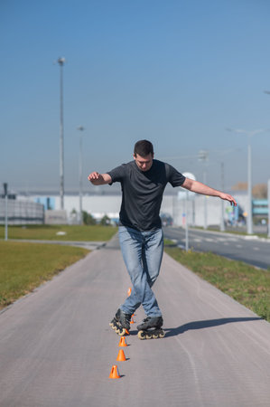 A Caucasian man rollerblades around the slalom course
