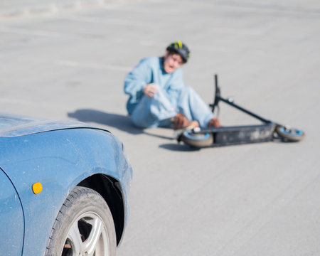 A Caucasian woman on a scooter after being hit by a carの写真素材