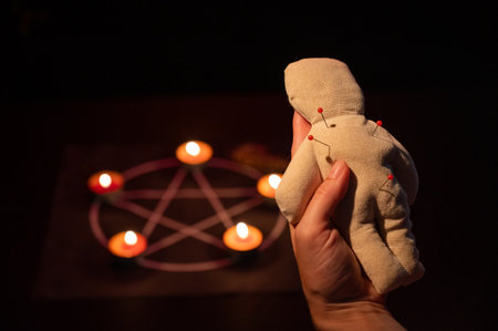 Woman sticking pins into voodoo dollの写真素材