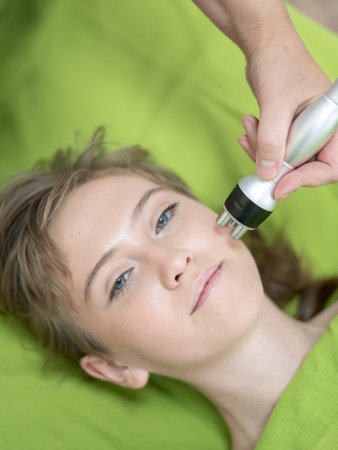 Top view of Caucasian woman undergoing radio wave RF lifting procedure in beauty salon