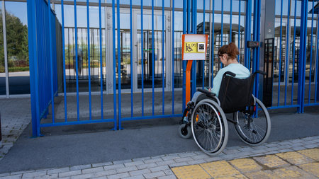 A woman in a wheelchair uses a call button for people with disabilitiesの写真素材