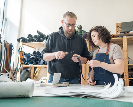 A man and a woman work as tanners in a workshop