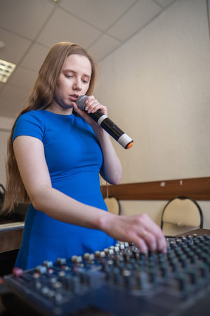 Young woman mixing live sound. Girl recording a song in the studioの写真素材