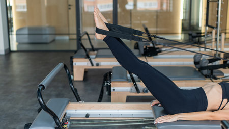 Caucasian woman doing exercises on reformer machineの写真素材